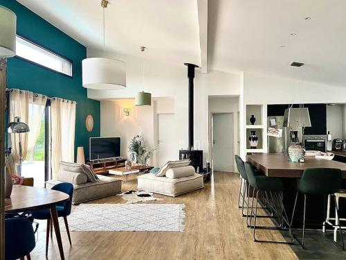 un salon avec un canapé et une salle à manger dans l'établissement Villa Bois Piscine Bordeaux, à Bonnetan