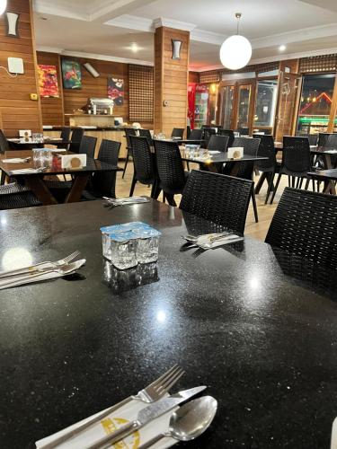 a dining room with a table with silverware and chairs at Hayde otel in Çamlıhemşin