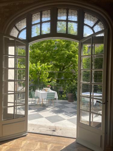 Une porte ouverte s'ouvre sur une terrasse avec une table. dans l'établissement Maison Dormoy, à Marseille