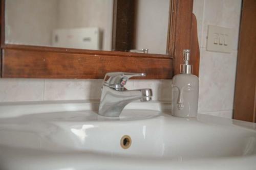 a bathroom sink with a soap dispenser on it at Casa Vacanze Le Cascate in Le Marmore