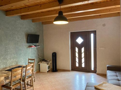 a living room with a door and a table and chairs at Alma Apartmanház in Harkány