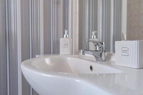 a white bathroom sink with a soap dispenser on it at Casa Vacanze Le Cascate in Le Marmore