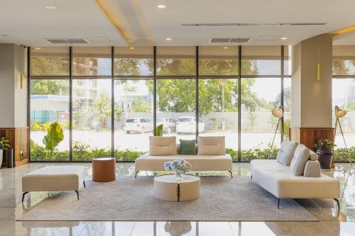 a living room with couches and a table and windows at Otres Beach Hotel in Sihanoukville