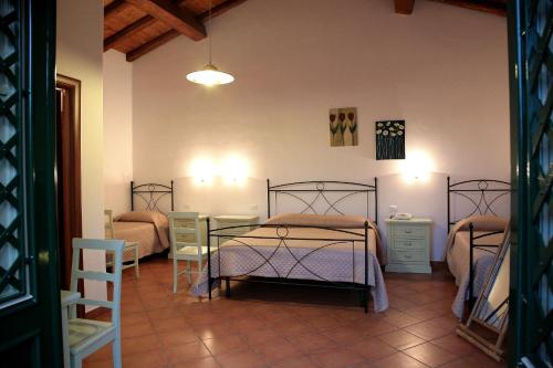 sypialnia z 2 łóżkami, stołem i krzesłami w obiekcie Lumia w mieście Riposto
