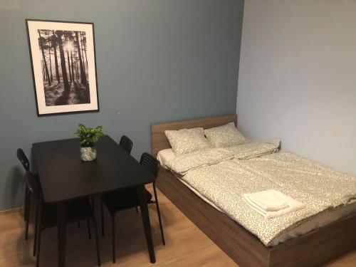 a small room with a bed and a table at Apartament Zwirki i Wigury 38 in Bydgoszcz