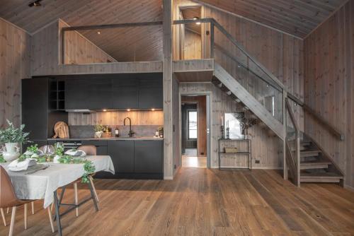 a kitchen and living room with a staircase in a house at Exclusive Penthouse Apartment with Sauna - 102 in Stranda