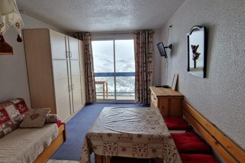 a room with a bed and a couch and a window at Studio au pied des pistes in Villarembert
