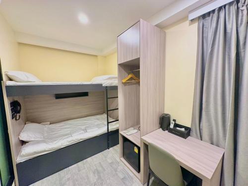Mały pokój z 2 łóżkami piętrowymi i biurkiem w obiekcie Nona Hotel, Bangkok w mieście Makkasan