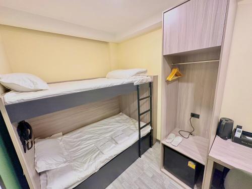 a small room with two bunk beds in it at Nona Hotel, Bangkok in Makkasan