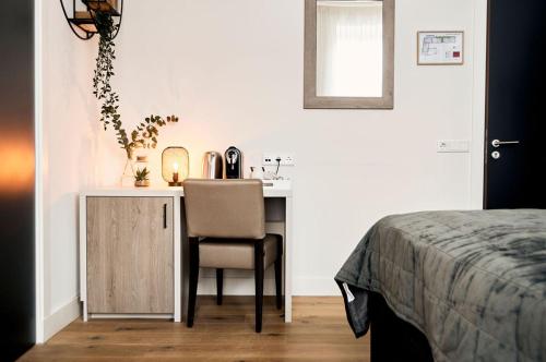 a bedroom with a desk and a chair and a bed at Hotel 't Peperhuys in Kaatsheuvel