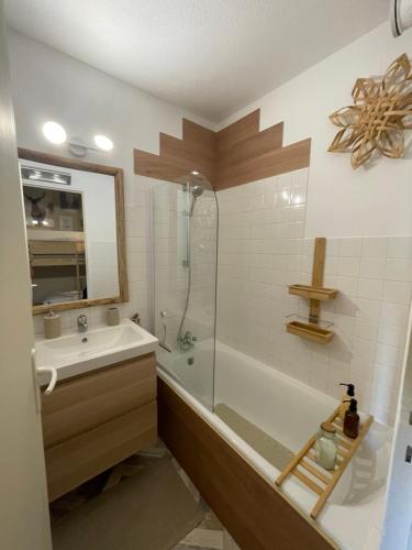 La salle de bains est pourvue d'une baignoire, d'un lavabo et d'une douche. dans l'établissement Les marmottes, à La Foux