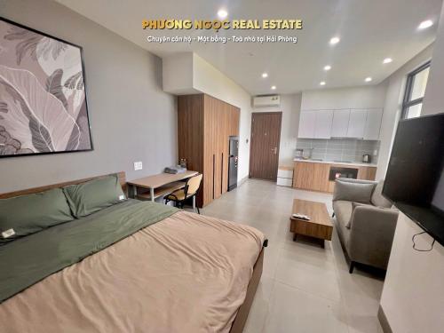 ein Schlafzimmer mit einem Bett und einem Sofa sowie eine Küche in der Unterkunft Căn hộ view Hoàng Hôn chuỗi Space Apartment & HomeStay tại Vinhomes Marina Hải Phòng in Xóm Niêm