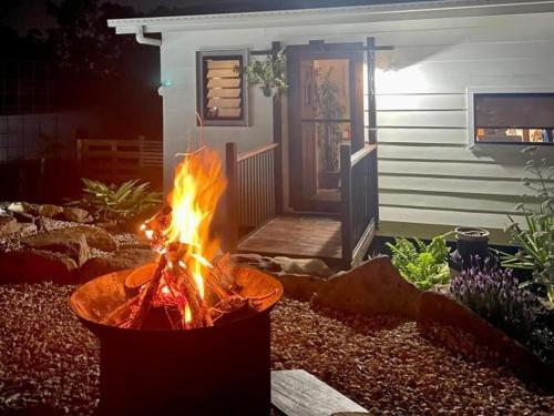 a fire pit in a yard in front of a house at Woodmans Cottage 24, Gold Coast Hinterland in Wongawallan