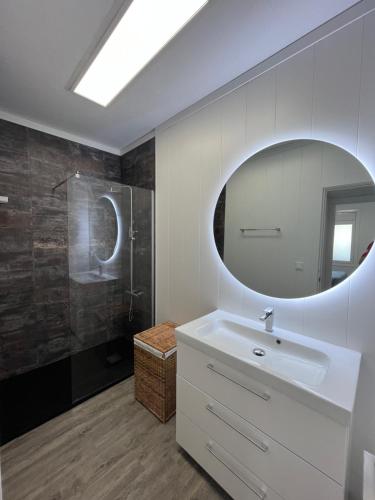 a bathroom with a sink and a mirror at Apartamento en la playa. Free Parking. Free WiFi in L'Escala