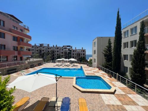 a large swimming pool with umbrellas and buildings at Vista Residence Apartments in Sveti Vlas