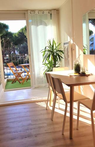 une salle à manger avec une table et des chaises ainsi qu'une terrasse dans l'établissement Superbe studio au calme à 8mn de la plage, à La Grande Motte