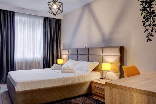 a bedroom with a large bed with two lamps at CHANTTAL Luxury - UNIVERSITY in Bucharest