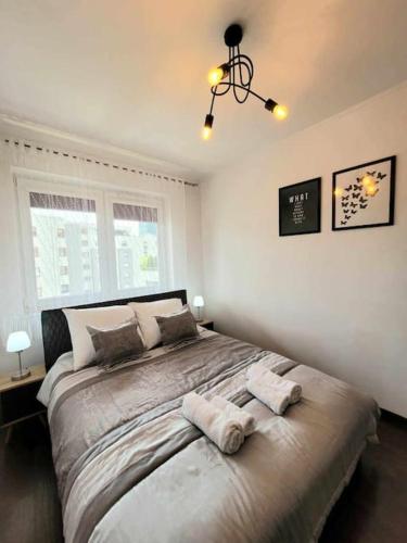 a bedroom with a large bed with two towels on it at Apartament Dark Chocolate 4 persons Down Town in Krakow