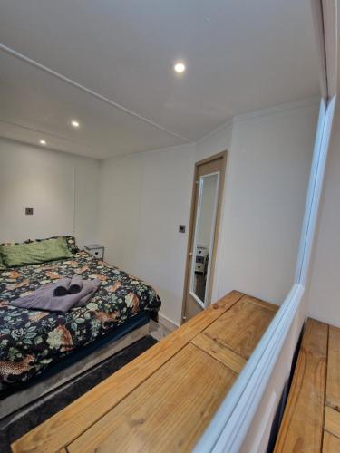 1 dormitorio con cama y mesa de madera en Featheredge Lodge, UK en Wells