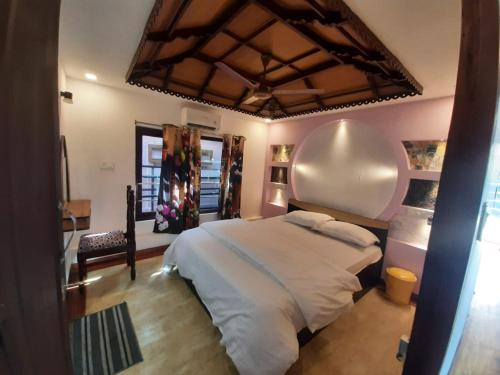 a bedroom with a large white bed in a room at Honeymoon Houseboat in Alleppey
