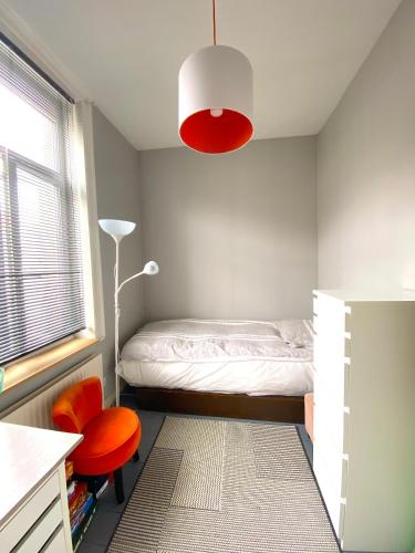 - une chambre avec un lit, un bureau et une chaise dans l'établissement Grande chambre + chambre d'appoint, à Ronchin