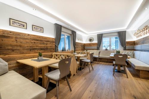a restaurant with wooden walls and tables and chairs at Aparthotel Jägerheim in Flachau