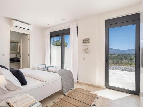 a white living room with a white couch and a window at Seacrete villas in Chania Town