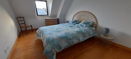 a bedroom with a bed with a blue and white comforter at Maison à L' arcouest proche embarcadere Bréhat in Ploubazlanec