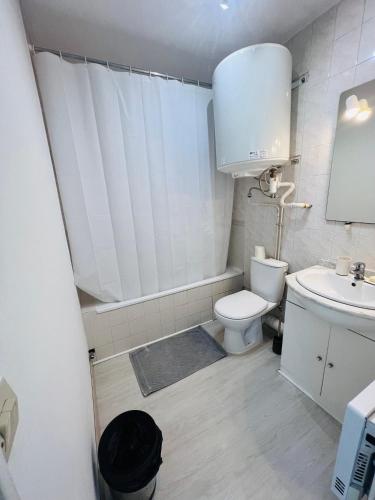une salle de bain blanche avec des toilettes et un lavabo dans l'établissement studio4 27m2 Terrasse Parking Piscine, à Saint-Laurent-du-Var