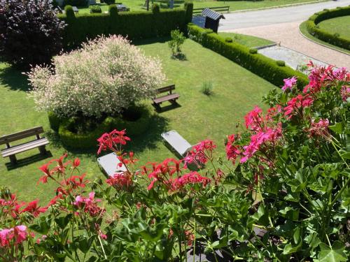 park z dwoma ławkami i różowymi kwiatami w obiekcie house Anna w mieście Jeziora Plitwickie
