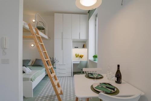a small apartment with a bed and a table and a ladder at Oliva Apartment in Imperia