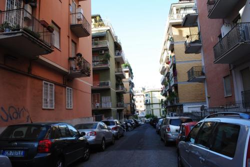 une rue avec des voitures garées sur les côtés des bâtiments dans l'établissement B&B Di Leo, à Rome