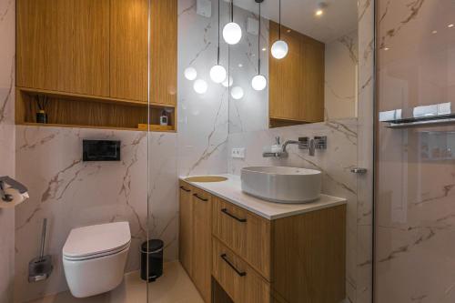 ein Bad mit einem Waschbecken und einem WC in der Unterkunft Baltic View REWAL 4-pax MOKKA in Rewal