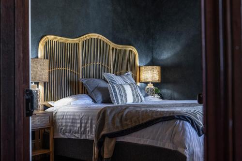 um quarto com uma cama grande e uma cabeceira dourada em Dal Zotto Homestead & Studios em Whitfield