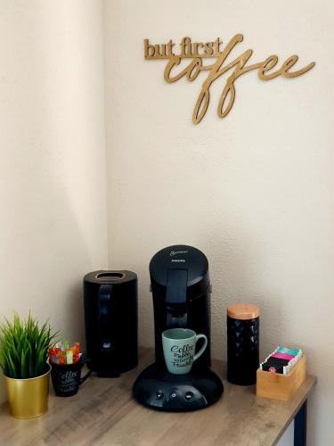 a coffee maker on a counter with a sign that says first coffee at ☆ Like @ home *☆ moderne Wohnung in Oberottmarshausen ☆ Netflix in Oberottmarshausen