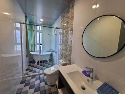 y baño con bañera, lavabo y espejo. en Sky Castle Homestay, en Fengbin