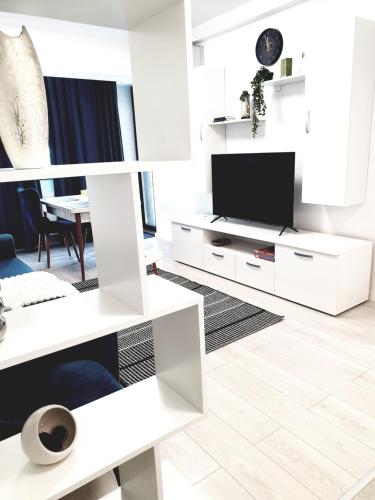 a living room with white furniture and a tv at Global Residence in Bucharest