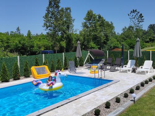 una piscina con dos niños en una balsa inflable en Vikendica Una na Drini en Loznica