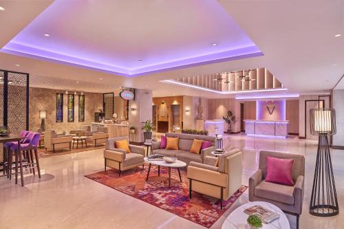 a lobby with couches and chairs and a table at Vivanta Jammu City Centre in Jammu