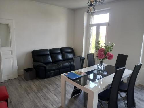 ストラスブールにあるGrand appartement au coeur de Strasbourgのリビングルーム(テーブル、黒革のソファ付)