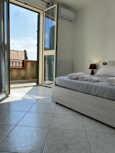 a bedroom with a bed and sliding glass doors at [la terrazza del sole] in Menfi