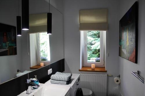 ナウェンチュフにあるStudio Nałęczówのバスルーム(洗面台、トイレ付)、窓2つが備わります。