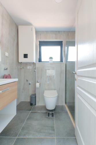 a bathroom with a toilet and a sink at Solana's View - Ferienhäuser in ruhiger Lage, mit einer einzigartigen Aussicht, Infinity Pool, Free Parking und Wlan in Ulcinj