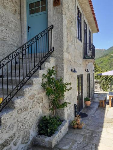 a stone house with a blue door and stairs at Villa Dos Santos - Gerês Country House in Geres