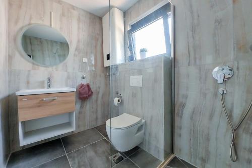 a bathroom with a shower and a toilet and a sink at Solana's View - Ferienhäuser in ruhiger Lage, mit einer einzigartigen Aussicht, Infinity Pool, Free Parking und Wlan in Ulcinj