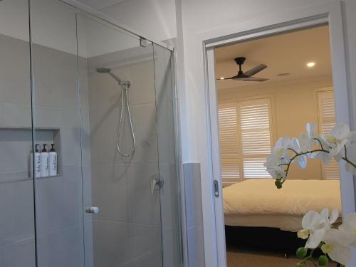 a bathroom with a walk in shower and a mirror at Bullseye in Yarrawonga