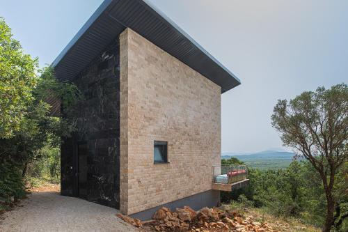 a brick house on a hill with a balcony at Solana's View - Ferienhäuser in ruhiger Lage, mit einer einzigartigen Aussicht, Infinity Pool, Free Parking und Wlan in Ulcinj
