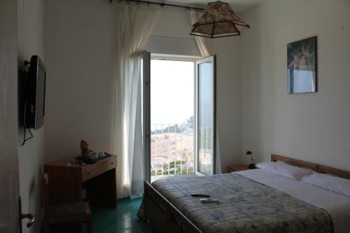 a bedroom with a bed and a large window at Hotel Esperia in Capri