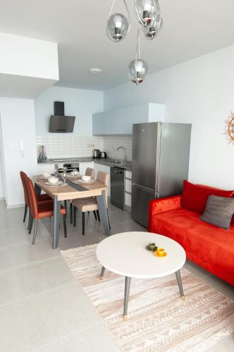 a living room with a red couch and a table at Seaview apartments in Ayios Elias
