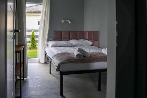 a bedroom with a bed with a book on it at Jej i Jego - Eleganckie domki z balią na wyłączność in Niewiesze